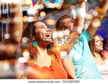 party, holidays, celebration, nightlife and people concept - smiling friends waving hands at concert in club Royalty-Free Stock Photo #301080389
