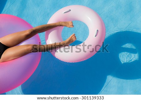 The pink life jacket floating in the pool and used to relax