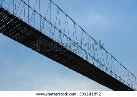 Silhouette Rope Bridge with Blue Sky Background