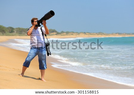 Young photographer taking photos at the beach