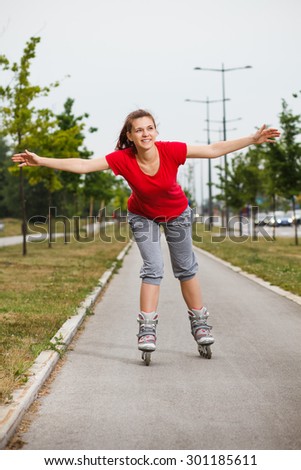 Cute young girl enjoys in roller skating.Sporty girl