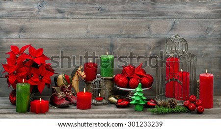 Vintage christmas decorations with red candles, flower poinsettia, stars and baubles. Retro style dark toned picture
