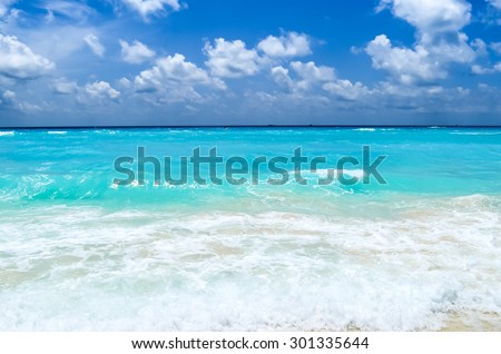 Turquoise water of the Caribbean sea on the background light white clouds and blue sky