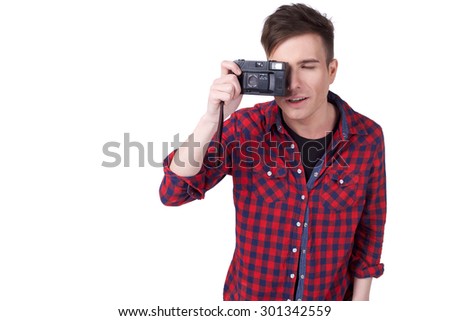 portrait of a young attractive man with a camera in hand isolated on white background . copy space