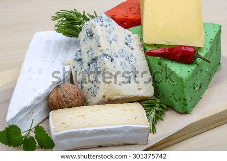 Assortment cheese with herbs on the wood background