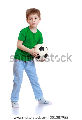 Little boy with short hair holding a soccer ball. A boy wearing a green T-shirt and blue jeans-Isolated on white background