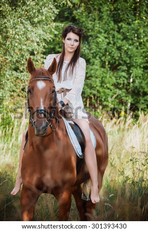 Portrait of a beautiful woman with a horse on nature