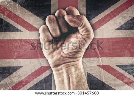 Great Britain riot fist with grunge UK flag in background, retro toned image