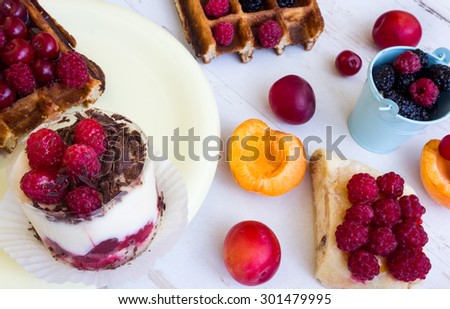 Belgian waffles with raspberry, cherry, mulberry on a white table. Cake with raspberry, poppy muffin, Belgian waffles