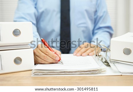 Midsection of businessman working  with financial documents at desk