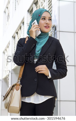 Young Beautiful Muslim business woman holding Smartphone 