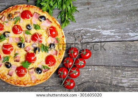 pizza with bacon, olives and tomato
