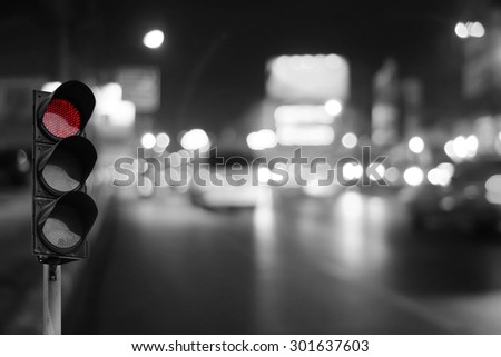 Red traffic light on the road in night city. dangerous signal stop crash driving highway,expressway. Blurred background of car dark fast truck surveillance security.