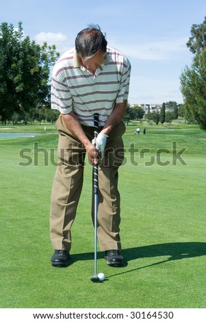 63 year old man putting on the green