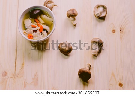 Traditional oriental pork broth with shiitake mushrooms on wooden table, Vintage picture
