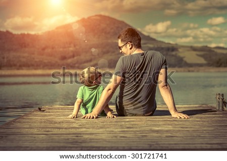Happiness father and son on the pier at sunny day under sunlight. Royalty-Free Stock Photo #301721741