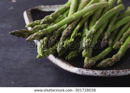Variety of seasonal vegetables: asparagus on the vintage black background