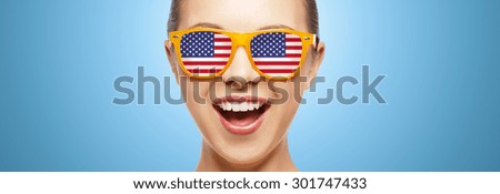 people, patriotism, national pride and independence day concept - happy teenage girl in sunglasses with american flag
