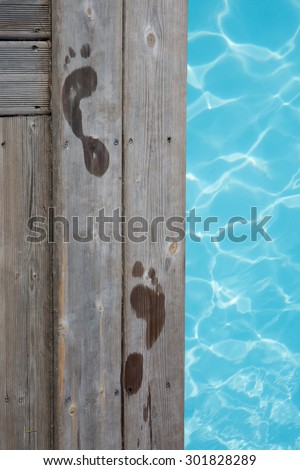 Wet human footprints on dark wooden plank floor