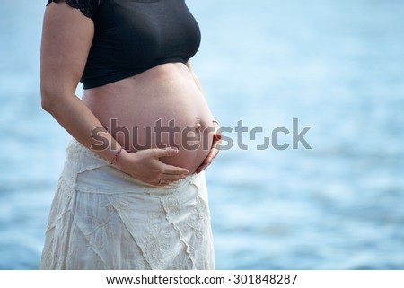 Pregnant woman holding hands over belly