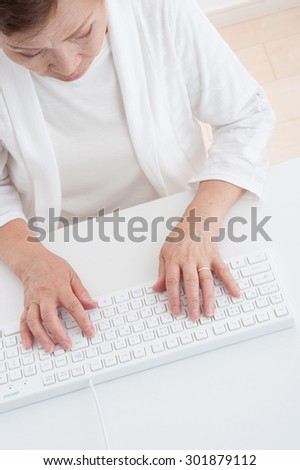 Asian elderly women who operates a computer keyboard