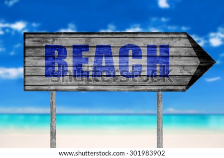 Beach wooden sign with a beach on background