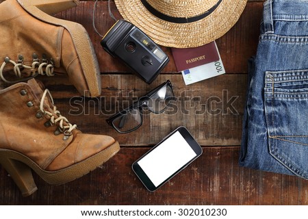 Outfit of traveler, student, teenager, young woman or guy. Overhead of essentials for modern young person. Different objects on wooden background.