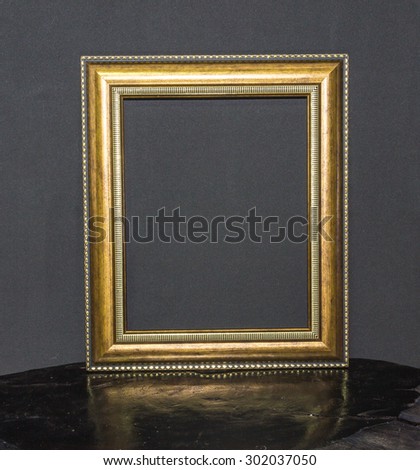Vintage picture frame on wood and on gray background.