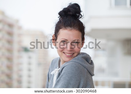 Beautiful smiling young woman on the balcony, casual cloth