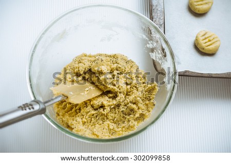 Raw lemon and poppy seed biscuit dough in a bowl, overhead shot.