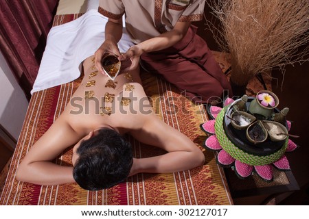 Man having oil Ayurveda spa treatment. Back and hands body part.