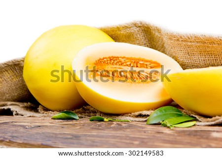 Photo of melon with leaves on burlap and wooden board