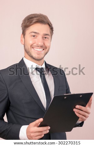 Love my  work. Upbeat handsome lawyer holding folder and smiling while looking forward
