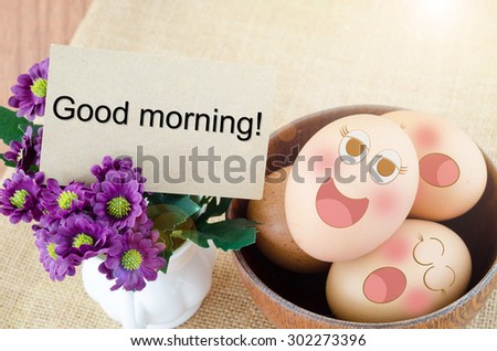 Good morning card and smile face eggs in wooden bowl on wooden background.