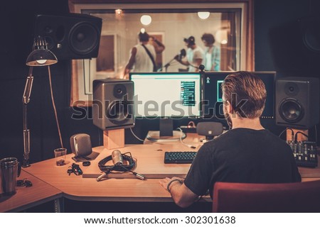 Music band during cd recording in studio  Royalty-Free Stock Photo #302301638
