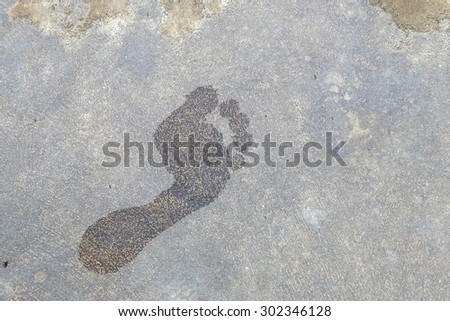 Closeup foot print at the floor , wet floor of foot shape on cement textured background , wet foot print pattern texture , foot print by man foot walk
