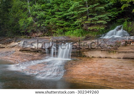 Elliot Falls, a waterfall in Upper Peninsula Michigan's Pictured Rocks National Lakeshore, cascades into Lake Superior at one end of Miners Beach.