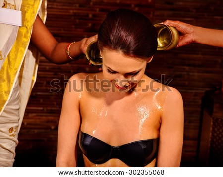 Woman having Ayurvedic spa treatment. Pouring milk.