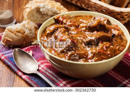 Beef stew served with crusty bread in a bowl Royalty-Free Stock Photo #302362730