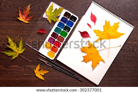 watercolor, brushes and autumn on a notepad