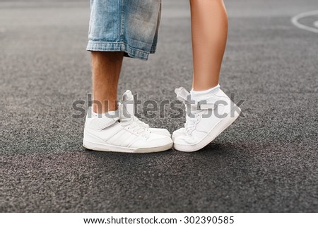 Young hip-hop couple kissing on the background of the asphalt. Kiss love standing.
Running white shoes closeup