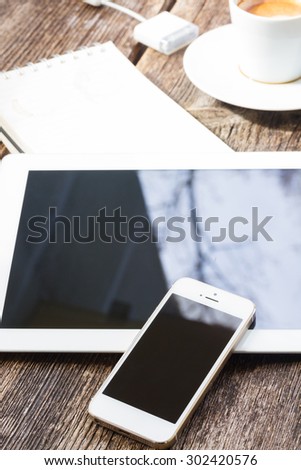 Coffee break with modern phone and tablet on wooden table