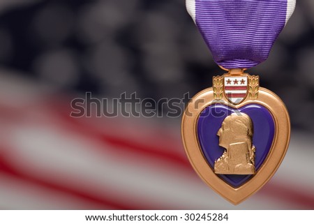Purple Heart Against a Blurry American Flag. Royalty-Free Stock Photo #30245284