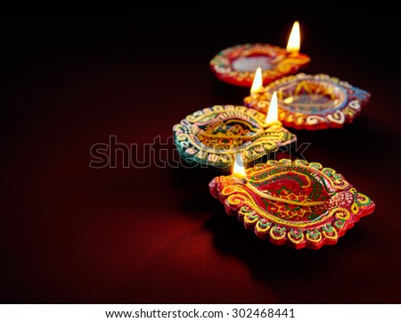 Colorful clay diya lamps lit during diwali celebration Royalty-Free Stock Photo #302468441