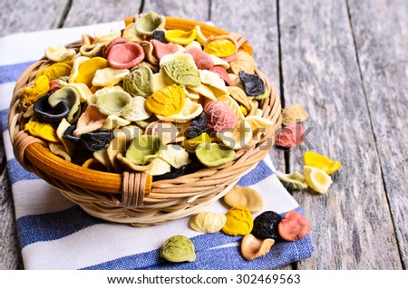 Pasta orecchiette in a wicker basket on a wooden surface