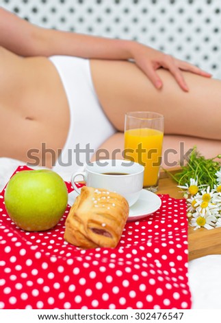 Breakfast in bed. Woman on background.