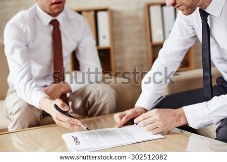 Businessman signing contract after discussing its terms with partner