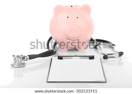 Piggy bank with stethoscope and clipboard isolated on white