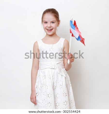 Proud little girl holding national flag of Russian Federation (Russia) and Victory Banner - Assault flag of the 150th Order of Kutuzov II Degree Idritsa Infantry Division in the second World War 