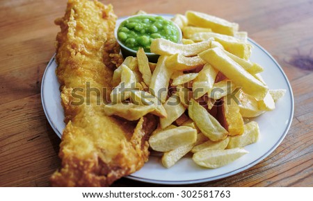 Delicious deep fried battered Cod Fish with Chips in a Fish and Chips restaurant in Greater London Royalty-Free Stock Photo #302581763